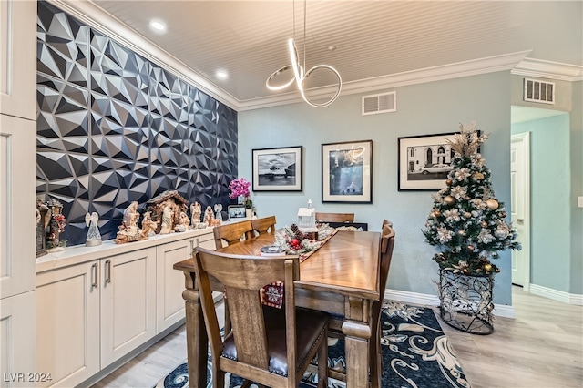 dining area featuring light hardwood / wood-style flooring and crown molding