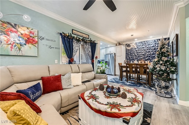 living room featuring ceiling fan, crown molding, and light hardwood / wood-style flooring