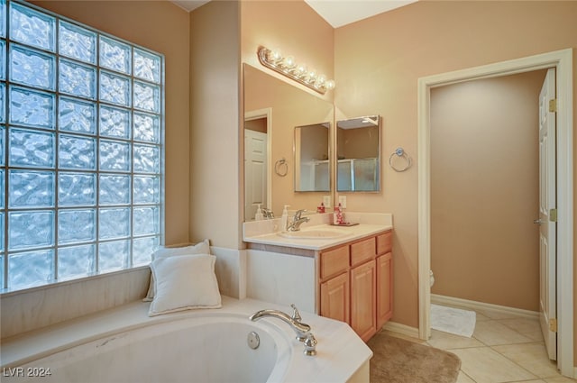 bathroom featuring tile patterned flooring, vanity, and a bath