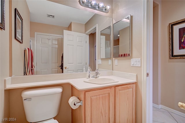 bathroom featuring tile patterned flooring, vanity, and toilet