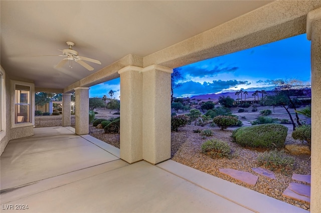 patio terrace at dusk featuring ceiling fan