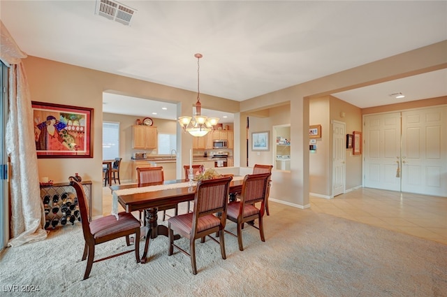 carpeted dining room with an inviting chandelier