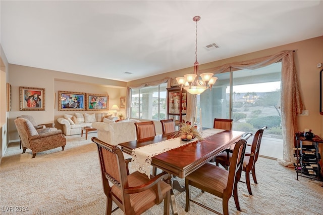 dining space featuring a chandelier, a healthy amount of sunlight, and light carpet