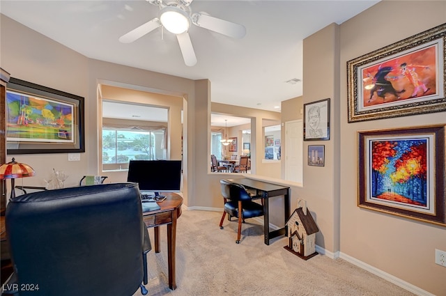 carpeted home office featuring ceiling fan with notable chandelier