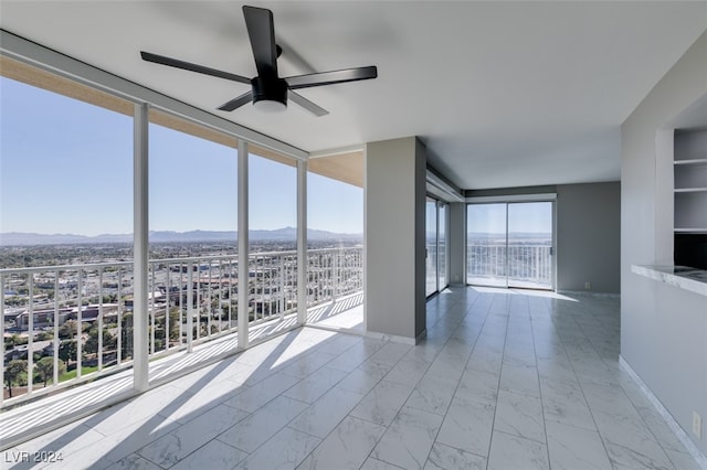 unfurnished sunroom with plenty of natural light and ceiling fan