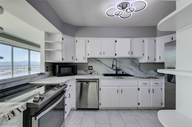 kitchen with white cabinets, stainless steel appliances, sink, and backsplash