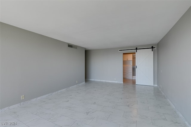 spare room featuring a barn door