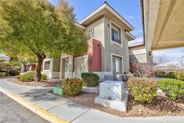 view of front of property with central AC unit and stucco siding