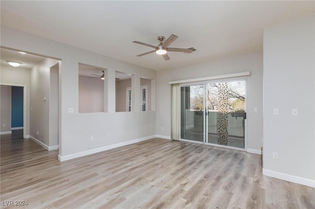 spare room featuring light wood-style floors, ceiling fan, and baseboards