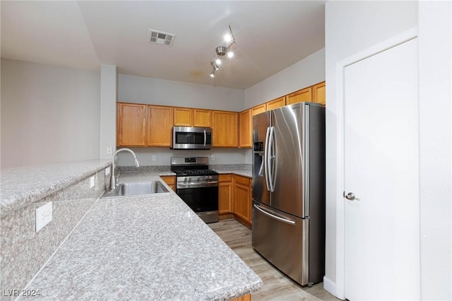 kitchen featuring light countertops, visible vents, appliances with stainless steel finishes, a sink, and a peninsula