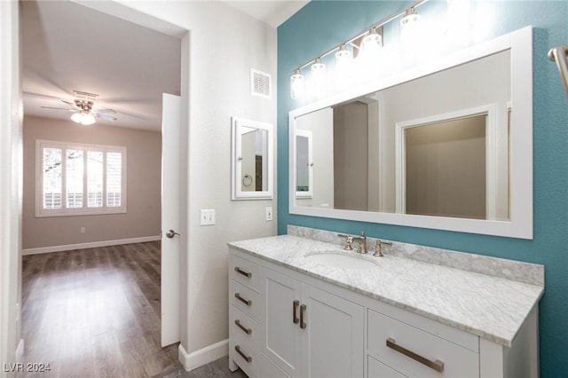 bathroom with ceiling fan, vanity, visible vents, and baseboards