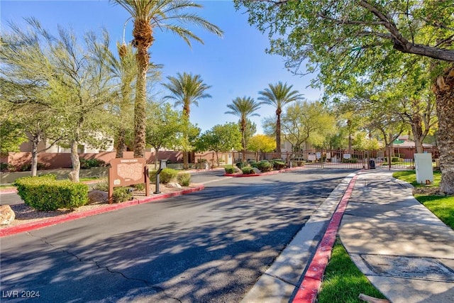 view of road featuring curbs, a gated entry, a residential view, and a gate