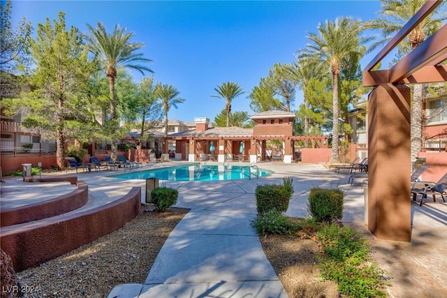 community pool with a patio area and a pergola