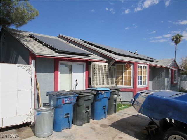 rear view of property featuring solar panels