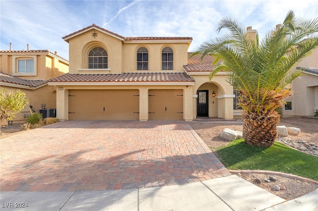 mediterranean / spanish-style home featuring central AC and a garage