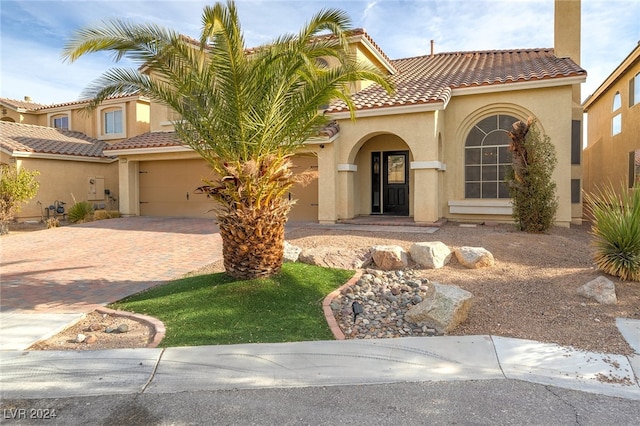 mediterranean / spanish home featuring a garage