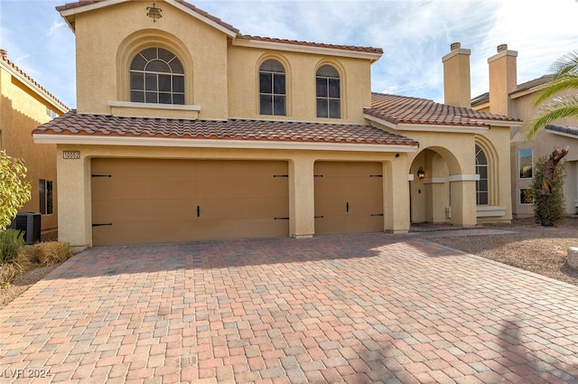 mediterranean / spanish-style house featuring central AC and a garage