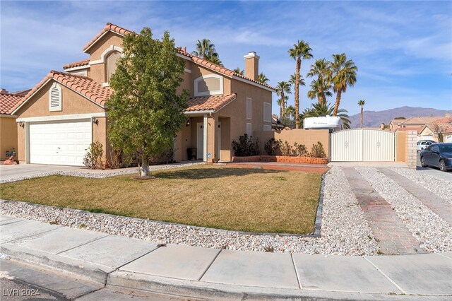 view of front of house with a mountain view, a garage, and a front yard