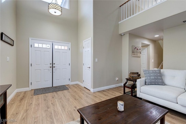 entrance foyer featuring plenty of natural light, light hardwood / wood-style floors, and a high ceiling