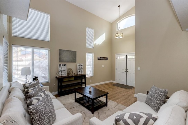 living room with light hardwood / wood-style floors and a high ceiling