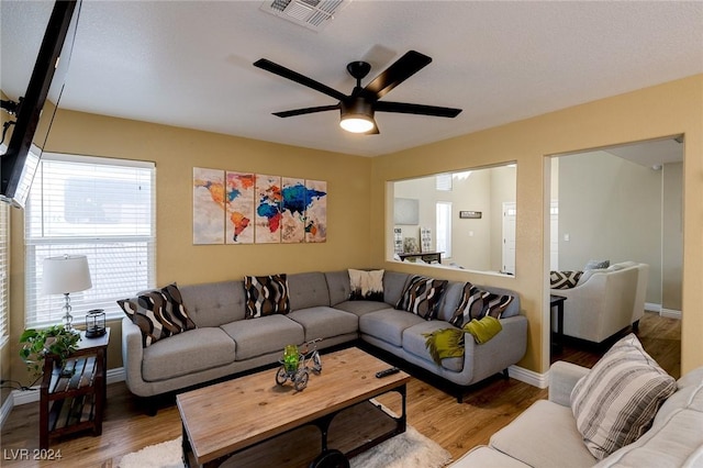 living room featuring hardwood / wood-style floors and ceiling fan