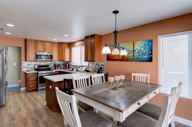 dining space with light hardwood / wood-style flooring and sink