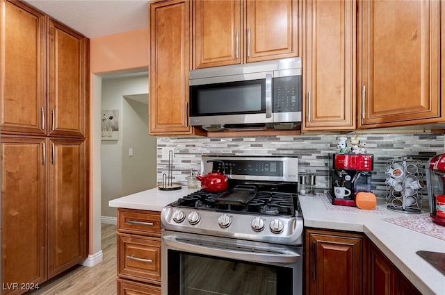 kitchen featuring tasteful backsplash, stainless steel appliances, and light wood-type flooring