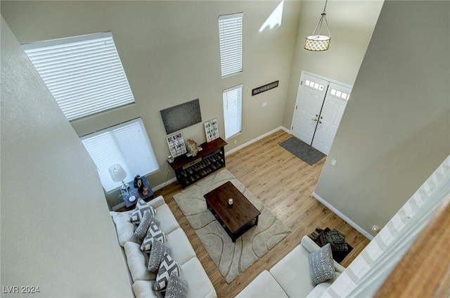 living room featuring light wood-type flooring and a high ceiling