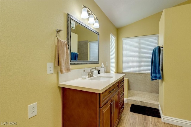 bathroom featuring vanity, wood-type flooring, and vaulted ceiling