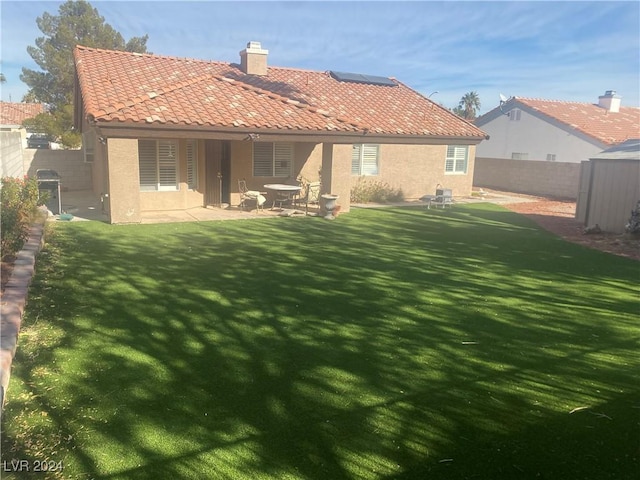 rear view of house featuring a patio and a yard