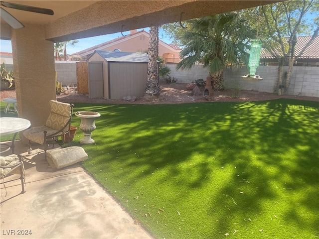 view of yard with a patio area, ceiling fan, and a shed