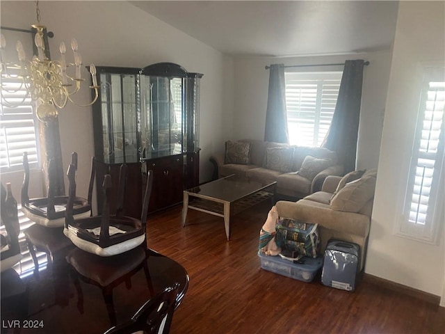 living room featuring dark wood-type flooring and an inviting chandelier