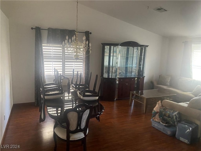 dining area with dark hardwood / wood-style floors and a chandelier