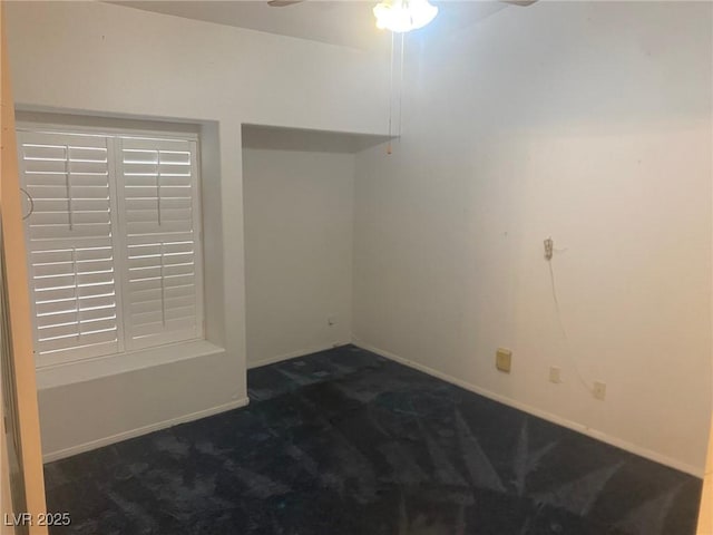 empty room with ceiling fan and dark carpet