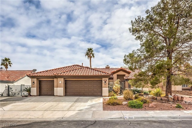 mediterranean / spanish-style home with driveway, a tiled roof, an attached garage, fence, and stucco siding