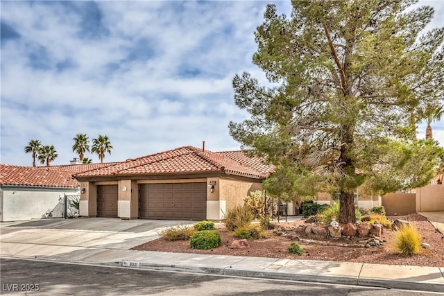 mediterranean / spanish home with a garage, fence, a tile roof, driveway, and stucco siding