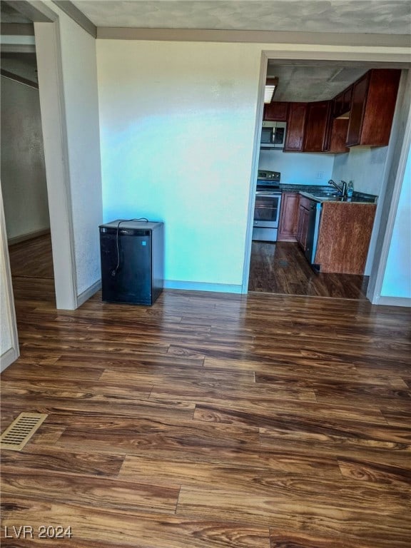 kitchen featuring dark wood-type flooring, appliances with stainless steel finishes, and sink