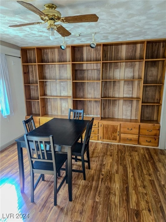 dining room featuring hardwood / wood-style floors, ceiling fan, and a textured ceiling
