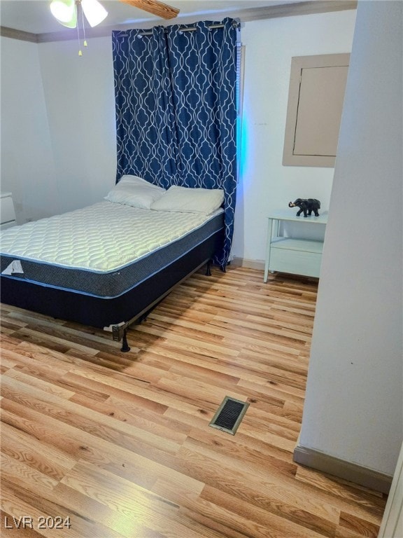 bedroom featuring ornamental molding, wood-type flooring, and ceiling fan
