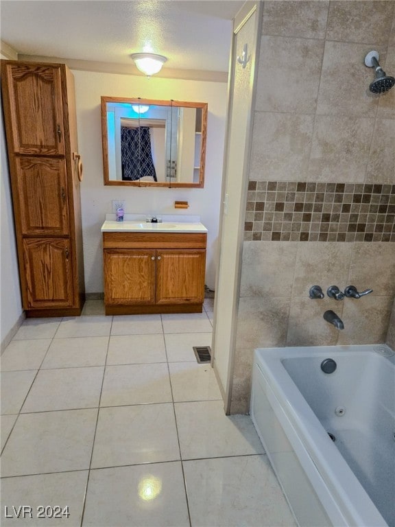 bathroom featuring vanity, tile patterned flooring, and tiled shower / bath combo