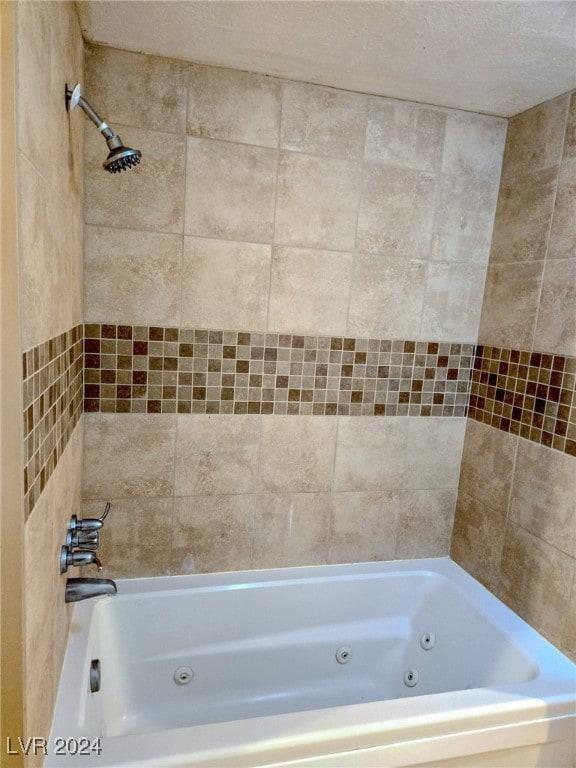 bathroom with tiled shower / bath and a textured ceiling