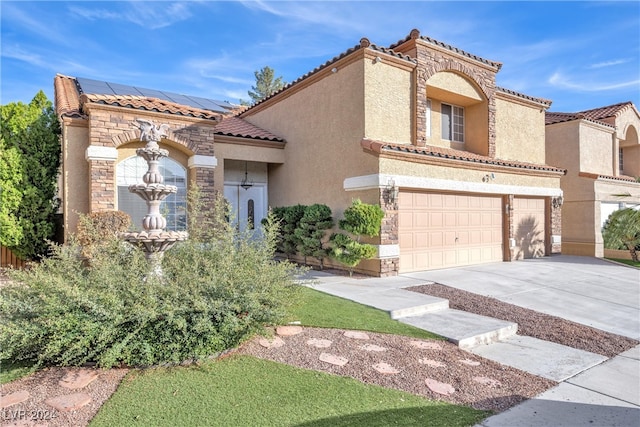 mediterranean / spanish-style home with a garage and solar panels