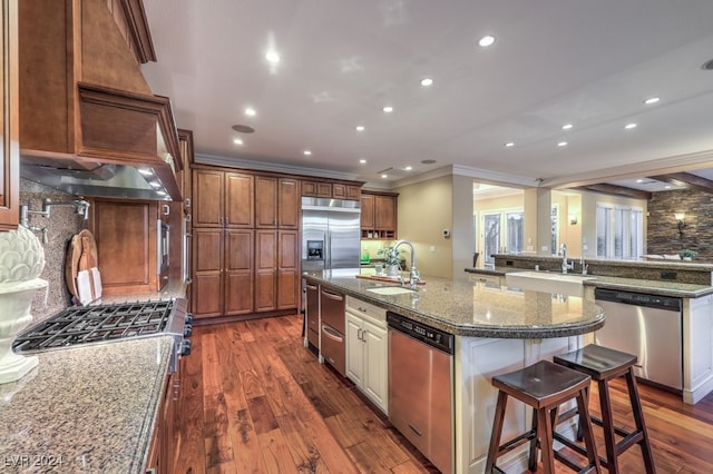 kitchen with sink, a spacious island, stainless steel appliances, and dark wood-type flooring