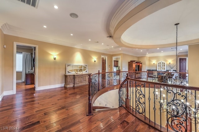 stairway featuring a tray ceiling, crown molding, and wood-type flooring