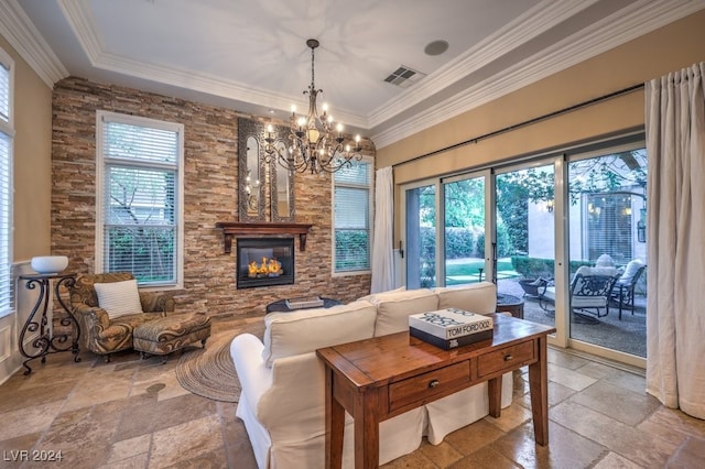 living room featuring a chandelier, a tray ceiling, crown molding, and a healthy amount of sunlight