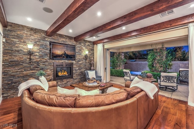 living room with beamed ceiling, wood-type flooring, and a fireplace