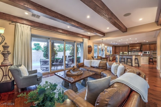 living room with beamed ceiling, dark hardwood / wood-style flooring, and a chandelier