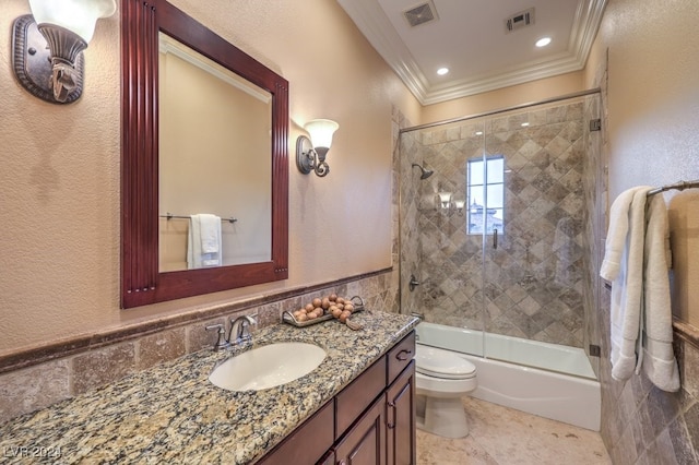 full bathroom with tile patterned floors, ornamental molding, vanity, enclosed tub / shower combo, and toilet