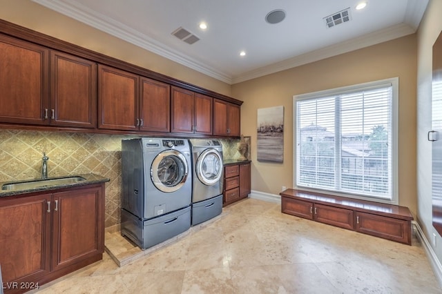 washroom with washing machine and clothes dryer, sink, cabinets, and ornamental molding