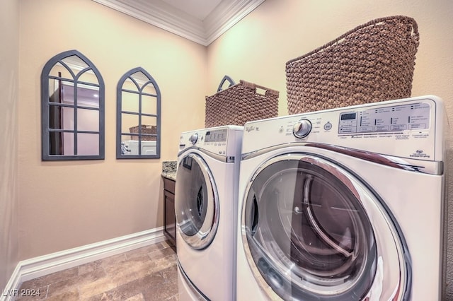 laundry room with independent washer and dryer, cabinets, and ornamental molding